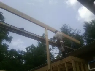 Carpenter setting a ridge beam over a new addition frame — Ice Dam Removal by Roofing Brothers in Cumberland Center