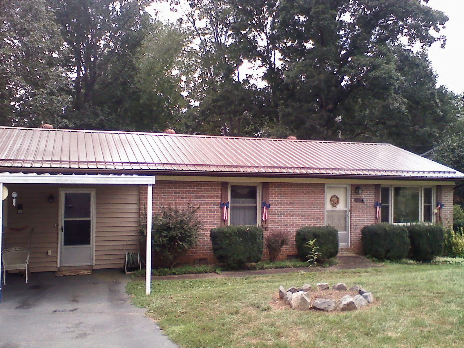 Bronze metal roof and carport on a brick ranch home — Roof Repair work by our crew in Cumberland Center